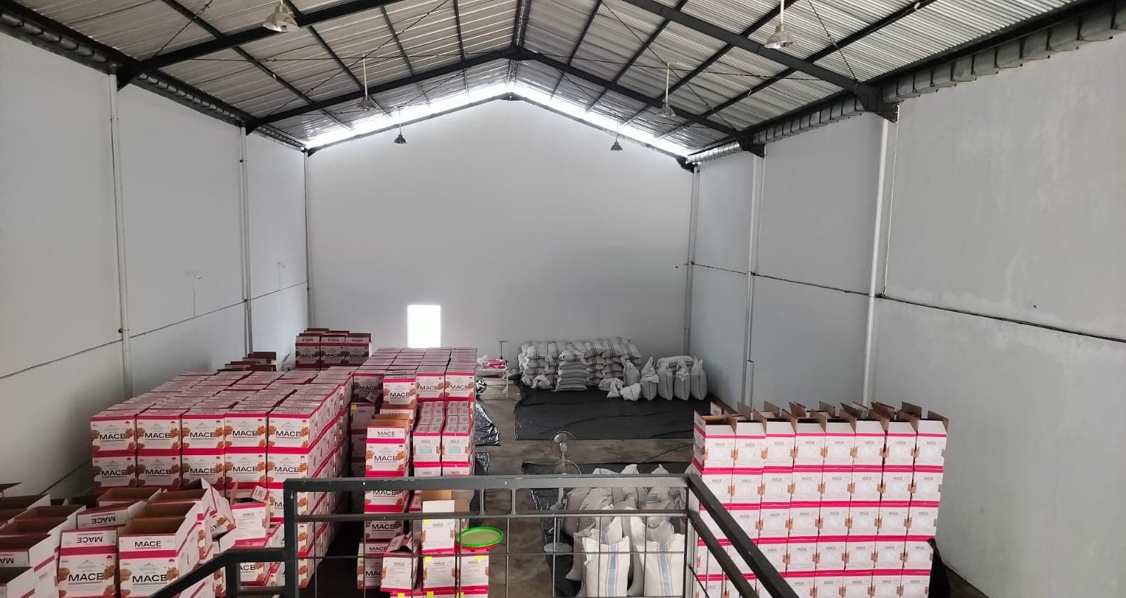 Full warehouse view with branded mace cartons and bulk storage